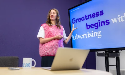 Eileen de Jong staat voor een beeldscherm waarop staat: Greatness begint met social advertising