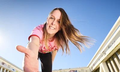 Judith van den Hazel staat op een trap en strekt haar hand uit