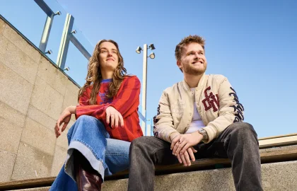 Eileen en Thijs zitten op een trap en kijken naar links